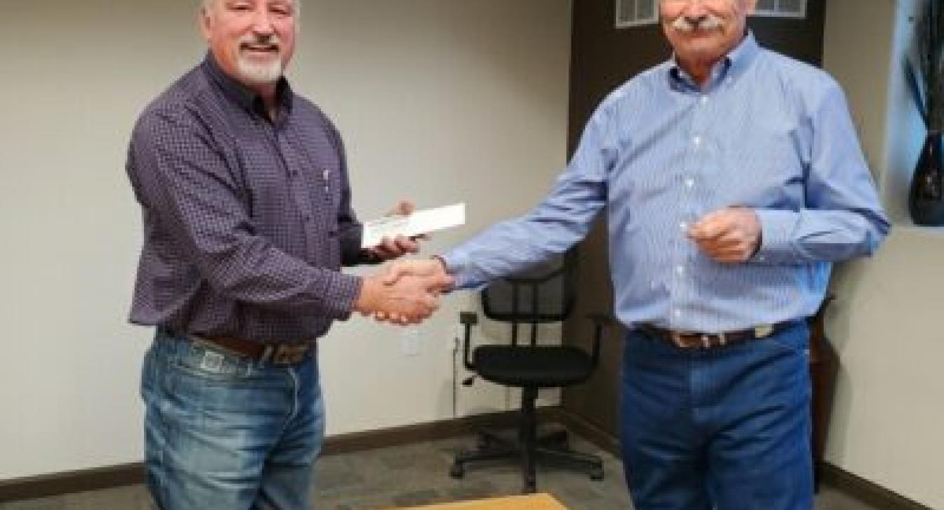 Retiring High West board member Jamie Fowler, LEFT, and board president Ed Prosser shake hands during the November board meeting. Fowler’s final meeting was on Monday, Dec. 21.